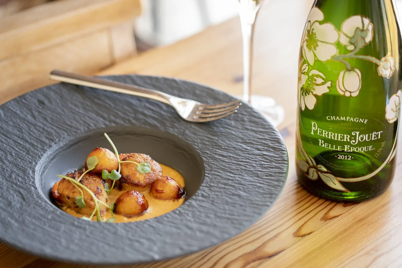 Seared king scallops plated on slate with a chorizo foam